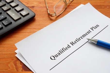 Qualified retirement plan, calculator and glasses.